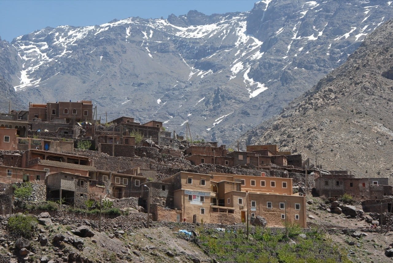 Berber village houses below the snow-streaked slopes of the High Atlas