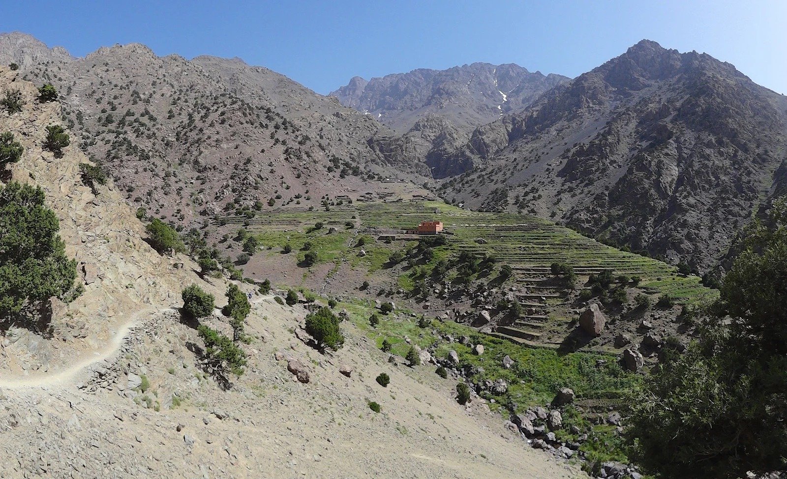 Path above terraced fields and a small house in an Atlas valley