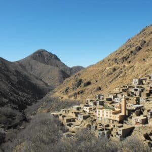 Berber village with its mosque tower on a hillside in a High Atlas valley
