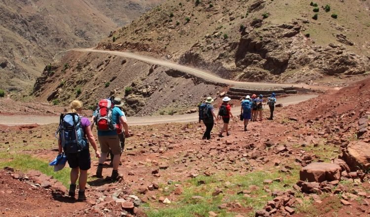 Group of trekkers on a red-earth track in the Atlas Mountains